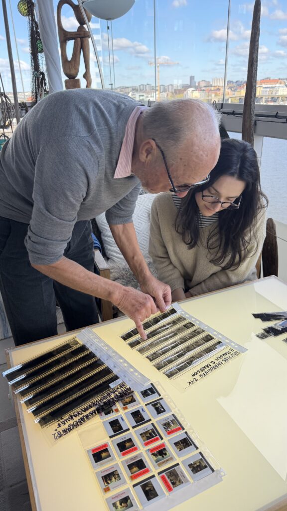 Kent Hult and an Ocean Archive archivist review original film strips on a light table.