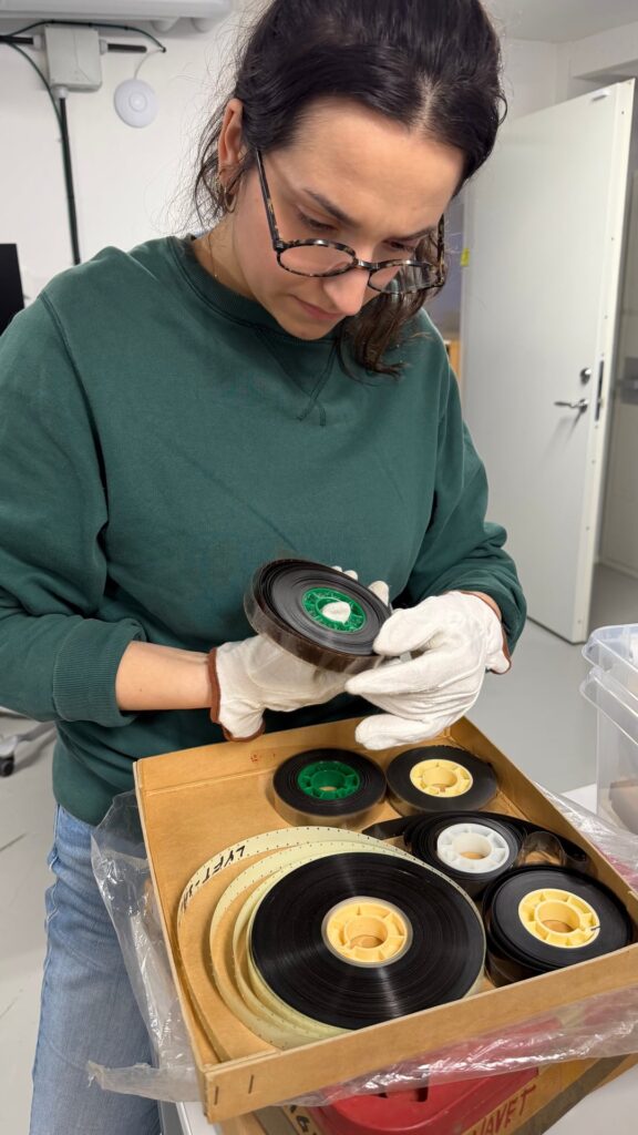 An archivist carefully inspects a film reel from the Börjesson collection.